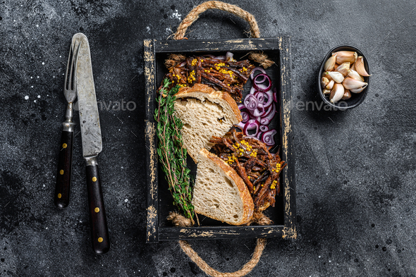 Pulled pork Sandwich with smoked pork meat in a wooden tray. Black background. Top view