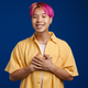 Asian boy with pink hair smiling while holding hands on his chest - PhotoDune Item for Sale