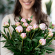 Smiling, happy woman holding a bunch of flowers indoors - PhotoDune Item for Sale