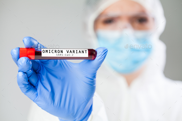 Doctor holding test tube specimen holder containing Omicron variant Coronavirus patient blood sample