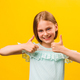 Studio portrait of stylish little children girl gesturing thumbs up looking at camera - PhotoDune Item for Sale