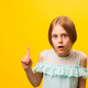 surprised amazed little americana children girl pointing finger up over yellow background. - PhotoDune Item for Sale