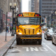 School bus USA. Yellow classic public bus on the street, only bus lane, American city downtown - PhotoDune Item for Sale