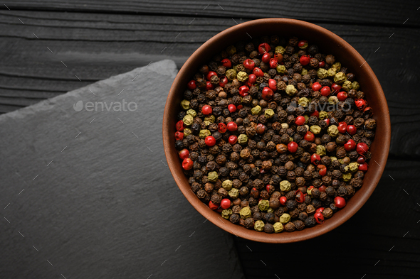 A mixture of different types of black pepper rustic backgrounds. Place for a logo.