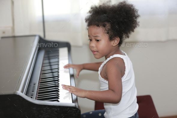 American African young pianist, Afro girl kid playing piano Stock Photo