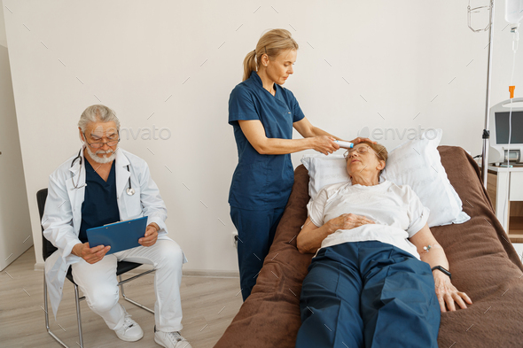 Close up of doctor measures patient\'s temperature with non-contact thermometer in hospital ward