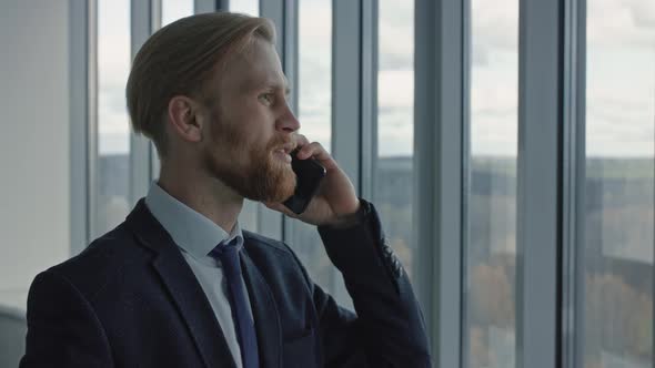Portrait of Serious Middle Age Businessman Answering Phone Call Modern Workplace