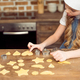 side view of little girl in chef hat making shaped cookies in kitchen - PhotoDune Item for Sale