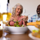 Low angle view of multiracial cheerful senior couple having lunch at dining table in nursing home - PhotoDune Item for Sale
