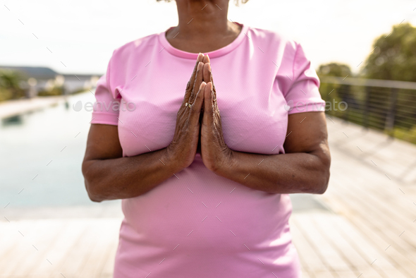 African american senior woman meditating in prayer pose while