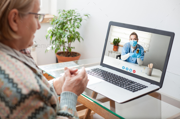 Young female doctor consulting with elderly woman over video help line virtual medical appointment