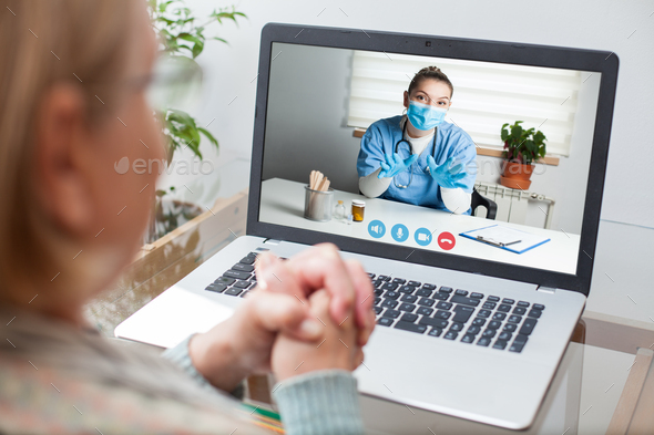 Young GP physician and elderly female patient consulting over video call - Stock Photo - Images