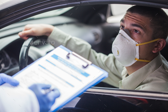 Young man wearing protective face mask in drive-thru Coronavirus car testing center - Stock Photo - Images