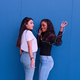 Two friends having fun dancing in front of a blue wall - PhotoDune Item for Sale