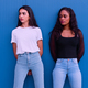 Portrait of two young girls of different ethnicity in front of a blue wall - PhotoDune Item for Sale