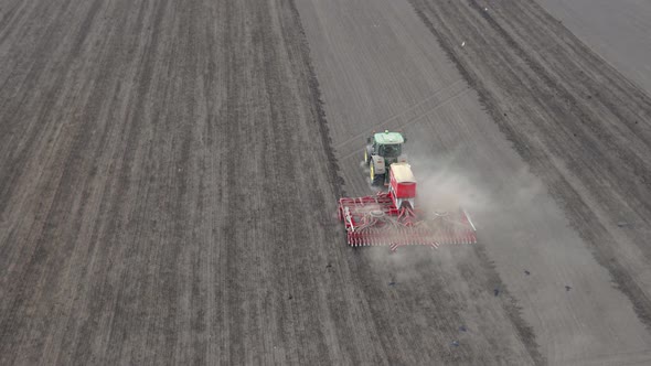 Tractor Sowing Seed on Plowed Field