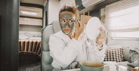 Young adult woman have care of her beauty using natural white cream mask on her face.