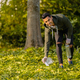 Smiling and committed volunteer cleaning garbage on grass in nature - PhotoDune Item for Sale