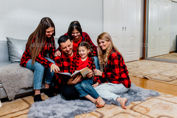 Young parents read the book to children at home. happy loving family.