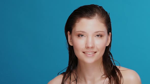 Pretty Girl with Wet Hair and Face Under Water Splashes Looking To Camera and Smiling alt
