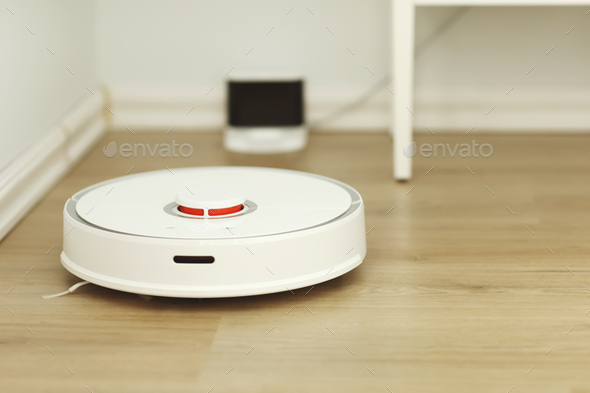 white robotic vacuum cleaner. The robot is controlled by voice commands for direct cleaning.