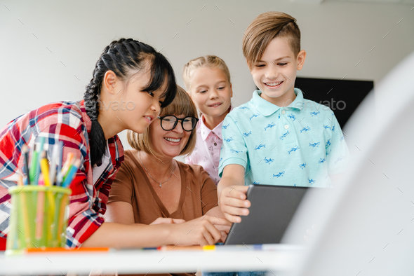 Multiracial teacher and students using tablet computer in art school - Stock Photo - Images