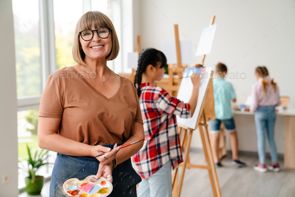 White teacher wearing eyeglasses smiling during class in art school - Stock Photo - Images