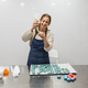 Confectioner woman smiling while preparing macarons in the kitchen of the bakery or confectionery - PhotoDune Item for Sale