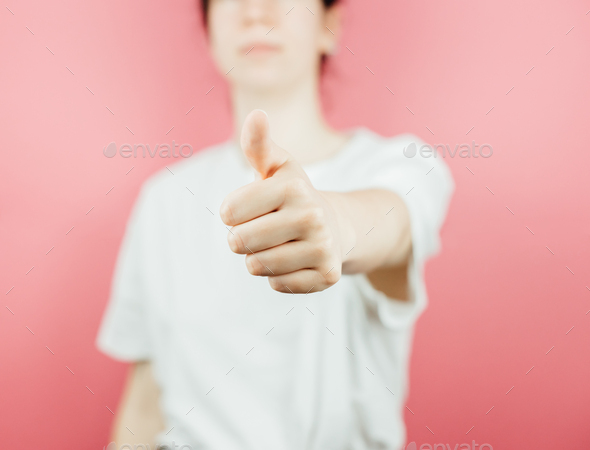 Woman doing the ok all good sign to camera over a pink background, help and self help