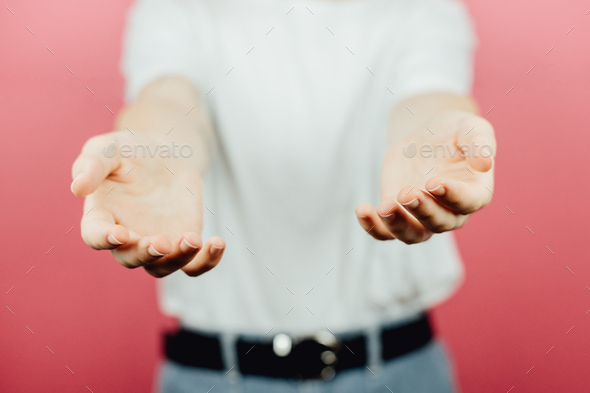 Woman giving hands to the camera over a pink background, help and self help concept, mental health