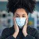 Young beautiful afro woman putting on an hygienic mask to prevent others from a virus - PhotoDune Item for Sale