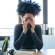 Exhausted young afro woman with headache working with computer in the office. - PhotoDune Item for Sale