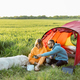 Couple and pet at campsite with tent on a green field - PhotoDune Item for Sale