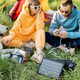 Man and woman charging phones with solar panel while traveling - PhotoDune Item for Sale