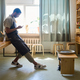 Side view of young male artisan in workwear scrolling in smartphone by workplace - PhotoDune Item for Sale