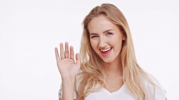 Young Beautiful Caucasian Blonde Girl Suprisingly Smiling on White Background in Slowmotion alt
