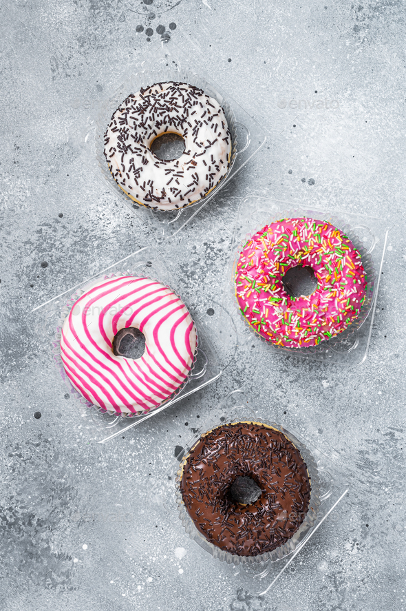 Assorted glazed donuts on a kitchen table. Gray background. Top view
