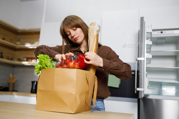 Young woman returned from shopping with a full package of products