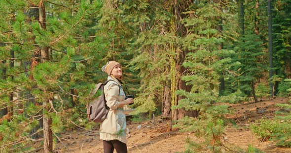 Traveler Woman Takes Pictures on Photo Camera in the Green Mountain Forest alt