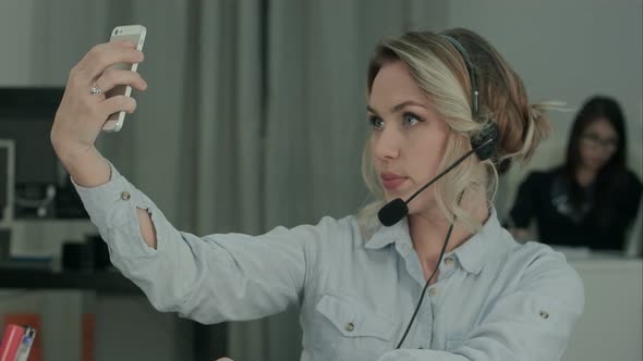 Pretty Call Operator Taking Phone Selfies While Talking To the Customer alt