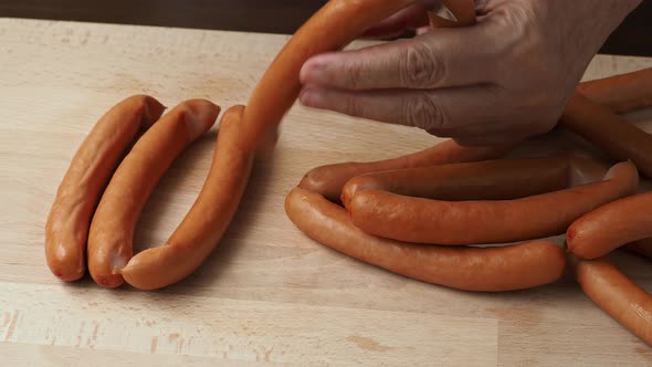 Thin pork sausages on the wooden cutting board