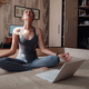 Attractive young woman exercising and sitting in yoga lotus position while resting at home - PhotoDune Item for Sale