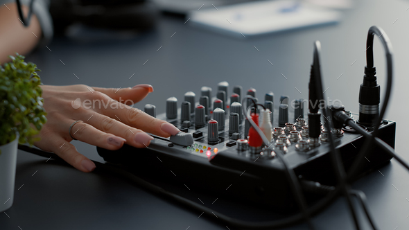 Influencer tweaking audio mixer knobs and buttons