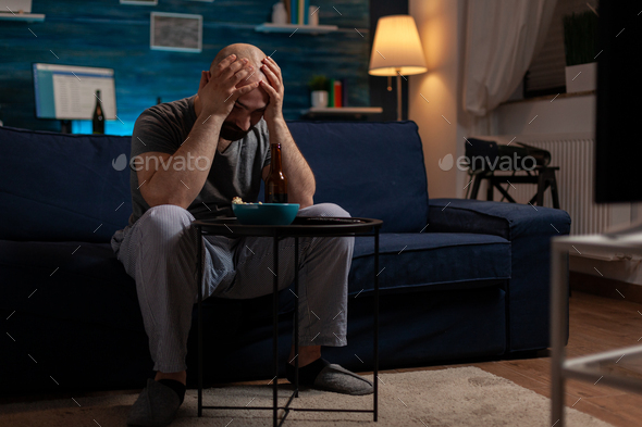 Frustrated man watching sports on television program