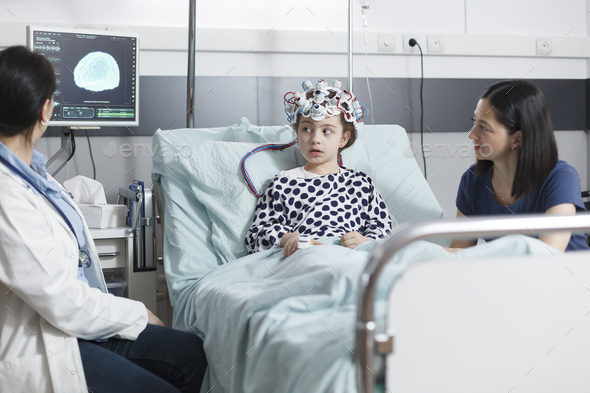 Pediatric medic analyzing electroencephalogram scan results of unwell little girl
