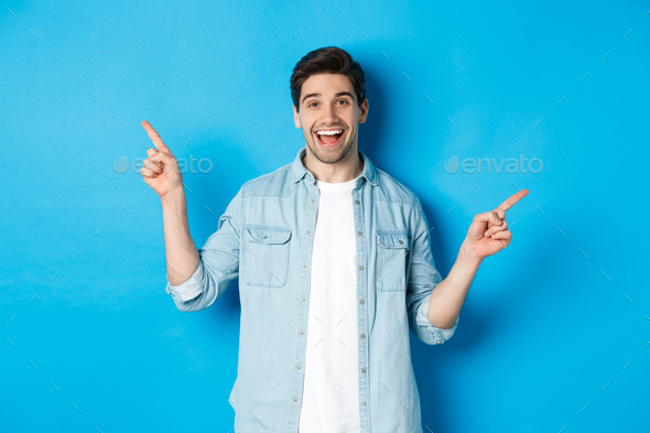 Cheerful adult man smiling, pointing fingers sideways, showing left and right promo banners