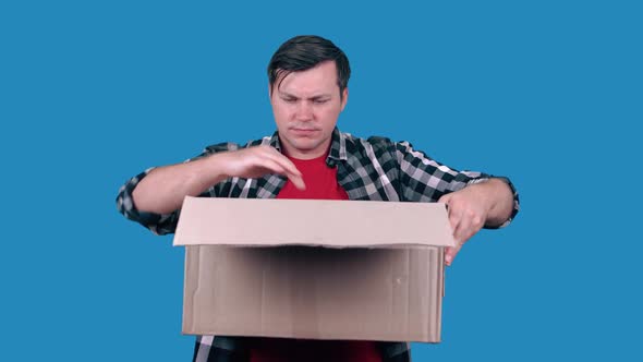 Astonished Caucasian man received a wrong order or an empty cardboard box