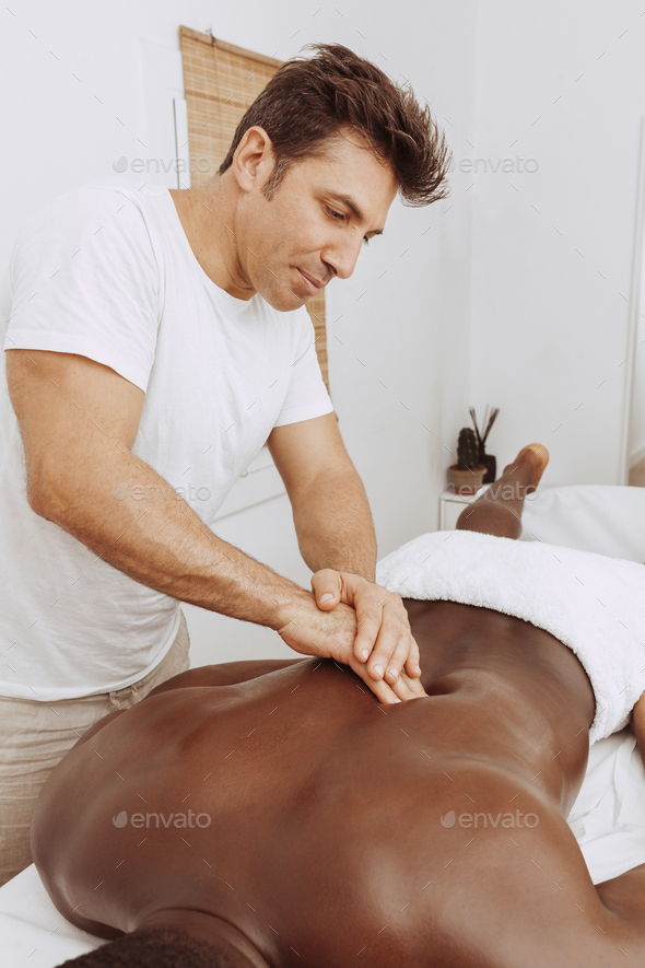 Physiotherapist working back therapy with black patient