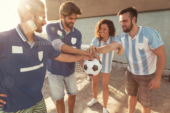 Friends holding a soccer ball before playing football