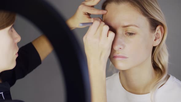 Artist Applies Makeup on Face of Attractive Fashion Model